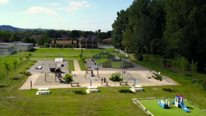  Vue a&eacute;rienne d'un terrain de jeu avec des &eacute;quipements de jeu color&eacute;s et des enfants jouant.