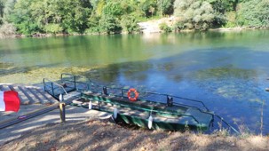 Un bateau amarr&eacute; sur la rivi&egrave;re, arborant un drapeau color&eacute;.