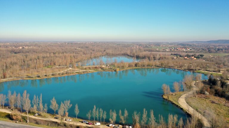 Vue a&eacute;rienne d'un lac entour&eacute; d'arbres verdoyants, offrant un paysage naturel apaisant.