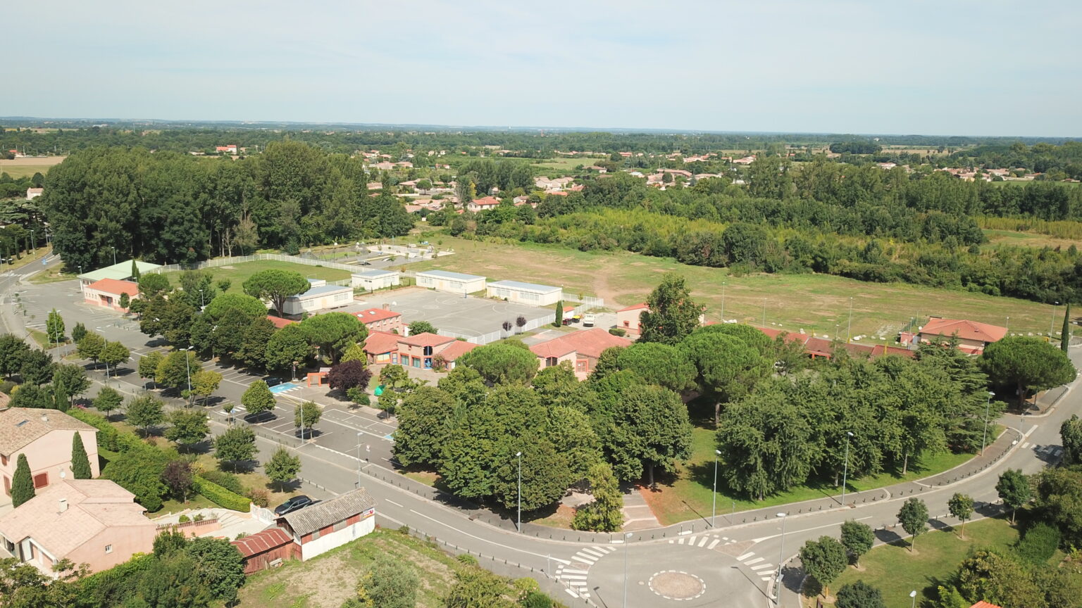  Vue a&eacute;rienne d'un quartier r&eacute;sidentiel avec des maisons et des arbres verdoyants.